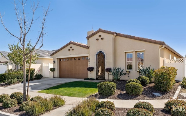 mediterranean / spanish-style house with concrete driveway, a tiled roof, an attached garage, fence, and stucco siding