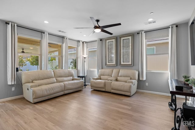 living area featuring light wood-style floors, baseboards, and visible vents