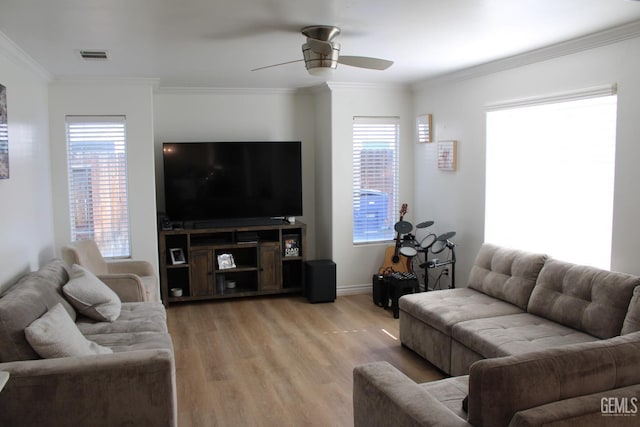 living room with ceiling fan, light hardwood / wood-style flooring, crown molding, and plenty of natural light