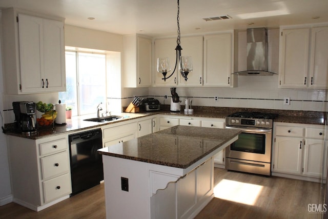 kitchen with a center island, stainless steel range oven, wall chimney range hood, and white cabinetry