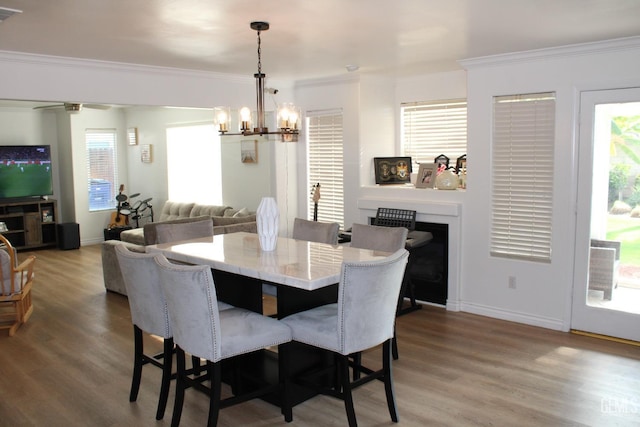 dining area with a wealth of natural light, crown molding, and hardwood / wood-style floors