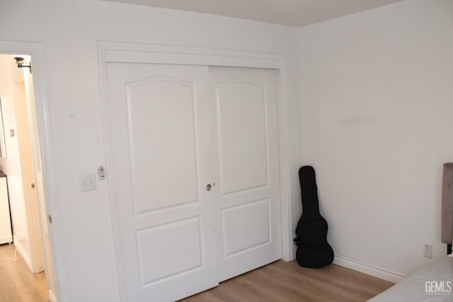 bedroom with a closet and light hardwood / wood-style flooring