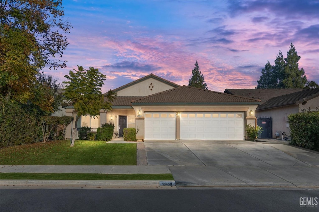 view of front of home featuring a lawn and a garage