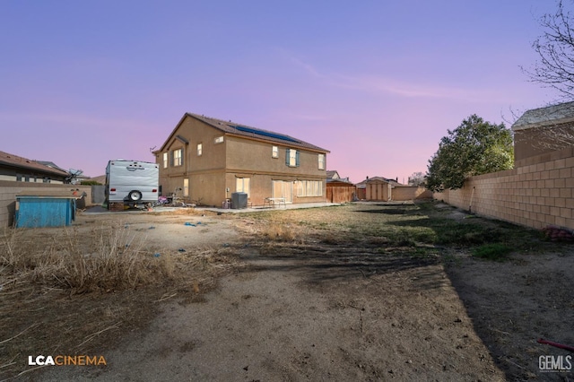 property exterior at dusk featuring central AC