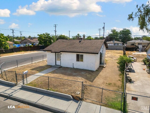 145 Kincaid St, Bakersfield, CA 93307 - view of front of property featuring a gate, stucco siding, and a shingled roof