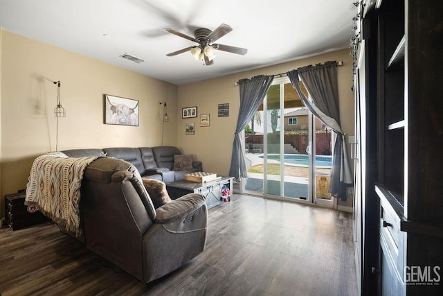 living room featuring ceiling fan and dark hardwood / wood-style floors