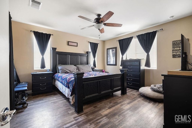 bedroom with ceiling fan, dark hardwood / wood-style flooring, and multiple windows