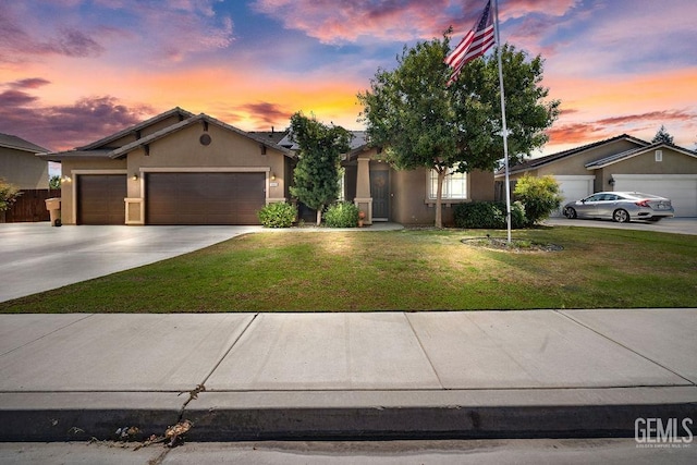 view of front of property with a garage and a lawn