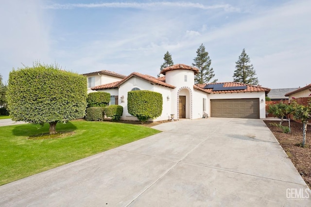 mediterranean / spanish-style home with solar panels, a front lawn, and a garage