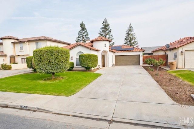 mediterranean / spanish home with solar panels, a garage, and a front lawn