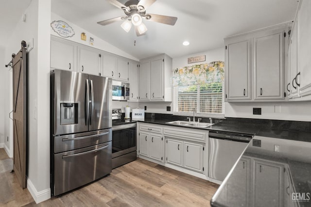 404 Mckinley St, Taft, CA 93268 - kitchen featuring appliances with stainless steel finishes, dark countertops, light wood-style flooring, a ceiling fan, and vaulted ceiling