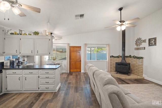 404 Mckinley St, Taft, CA 93268 - kitchen featuring a ceiling fan, dark wood-type flooring, white cabinets, a wood stove, and lofted ceiling