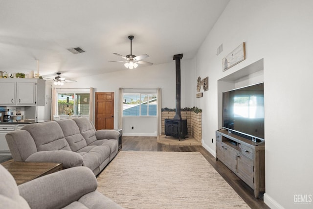 404 Mckinley St, Taft, CA 93268 - living room featuring a wood stove, dark wood-type flooring, a ceiling fan, and lofted ceiling
