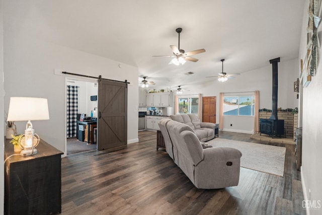 404 Mckinley St, Taft, CA 93268 - living room featuring a barn door, dark wood-type flooring, ceiling fan, a wood stove, and lofted ceiling