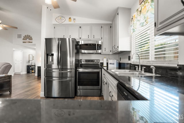 404 Mckinley St, Taft, CA 93268 - kitchen with stainless steel appliances, a ceiling fan, vaulted ceiling, dark countertops, and dark wood-style flooring