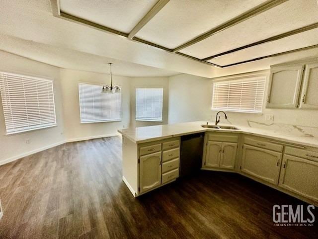 kitchen with light countertops, dishwasher, a peninsula, and a sink