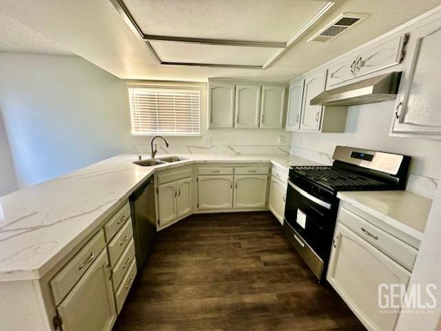 kitchen with visible vents, dark wood-type flooring, stainless steel appliances, under cabinet range hood, and a sink