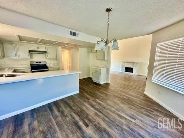 kitchen with under cabinet range hood, stainless steel electric range oven, visible vents, and light countertops