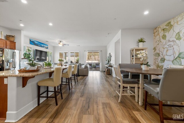 9700 Kingsport Pl, Bakersfield, CA 93306 - kitchen featuring stainless steel fridge, wood finished floors, recessed lighting, a breakfast bar area, and open floor plan