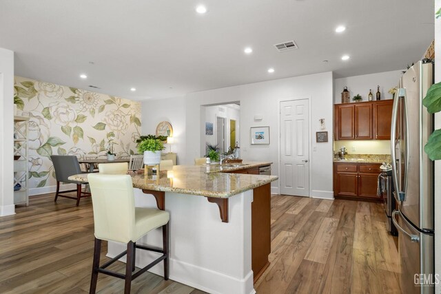 9700 Kingsport Pl, Bakersfield, CA 93306 - kitchen with stainless steel appliances, recessed lighting, wood finished floors, light stone counters, and a sink