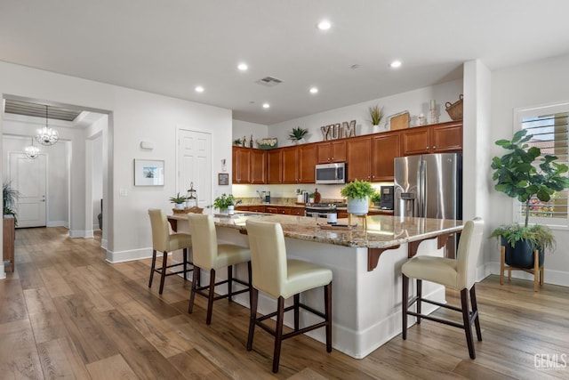 9700 Kingsport Pl, Bakersfield, CA 93306 - kitchen with appliances with stainless steel finishes, recessed lighting, wood finished floors, baseboards, and a breakfast bar
