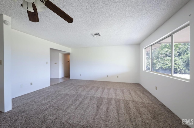carpeted empty room with a ceiling fan, a textured ceiling, and a smoke detector
