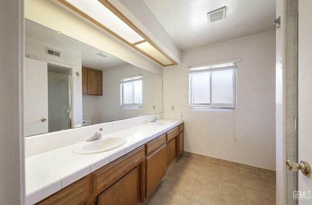 full bathroom with toilet and double vanity