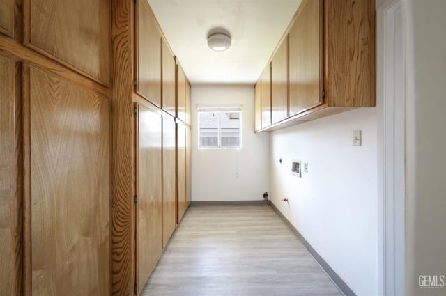 laundry room featuring electric dryer hookup, gas dryer hookup, light wood-type flooring, washer hookup, and cabinet space