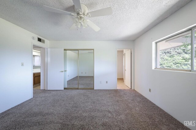 unfurnished bedroom with carpet floors, a closet, a textured ceiling, and ceiling fan