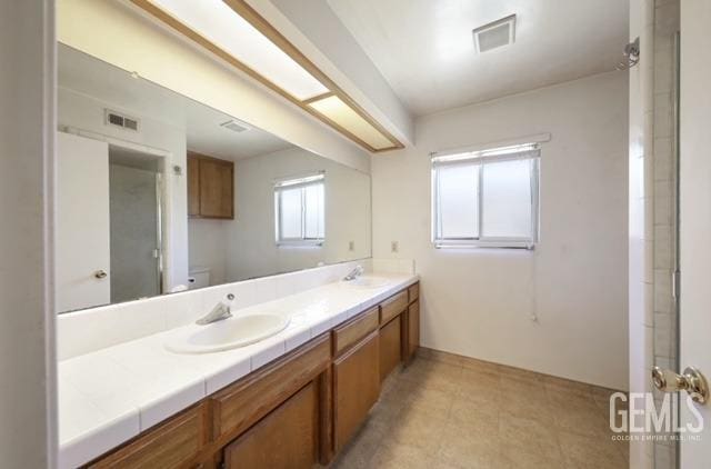 bathroom with double vanity and toilet