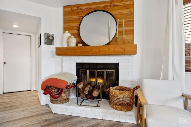 details with wood-type flooring and a brick fireplace