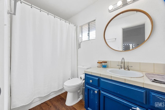 bathroom featuring vanity, wood-type flooring, and toilet