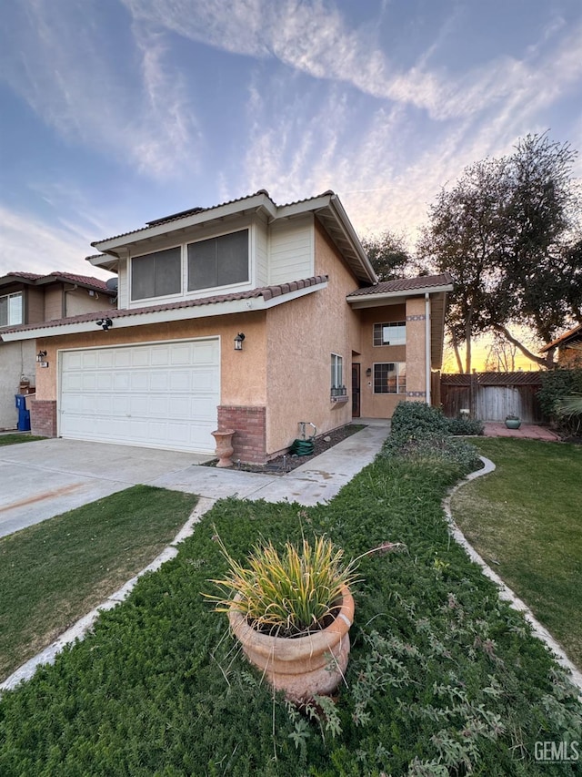 view of front of property featuring a garage and a lawn