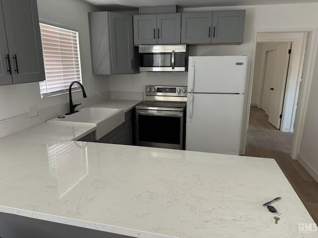 kitchen featuring gray cabinets, sink, and stainless steel appliances