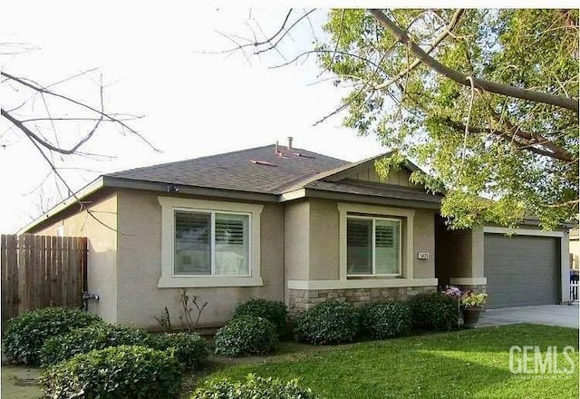 5429 White Wheat Ave, Bakersfield, CA 93313 - view of home's exterior with an attached garage, a shingled roof, concrete driveway, and stone siding