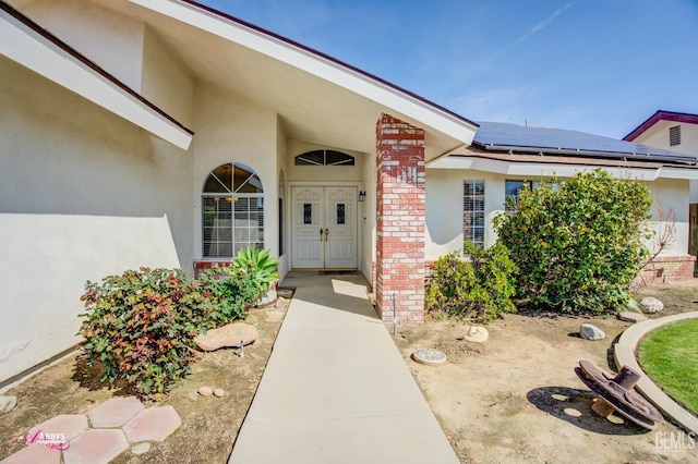 9812 Marilee Ave, Bakersfield, CA 93312 - doorway to property with brick siding, solar panels, and stucco siding