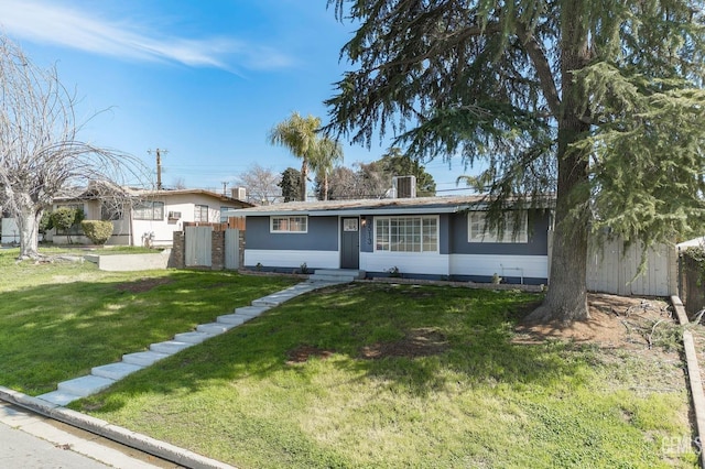 single story home with entry steps, fence, and a front yard