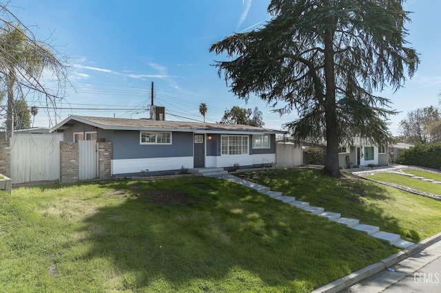 single story home featuring entry steps, brick siding, fence, stucco siding, and a front lawn