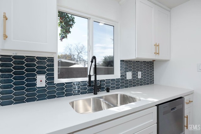 kitchen with white cabinets, light countertops, a sink, and stainless steel dishwasher