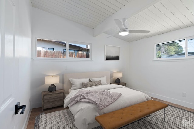 bedroom featuring baseboards, wooden ceiling, ceiling fan, wood finished floors, and vaulted ceiling with beams