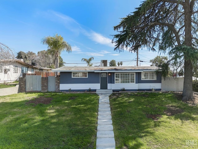 single story home with a gate, fence, and a front lawn