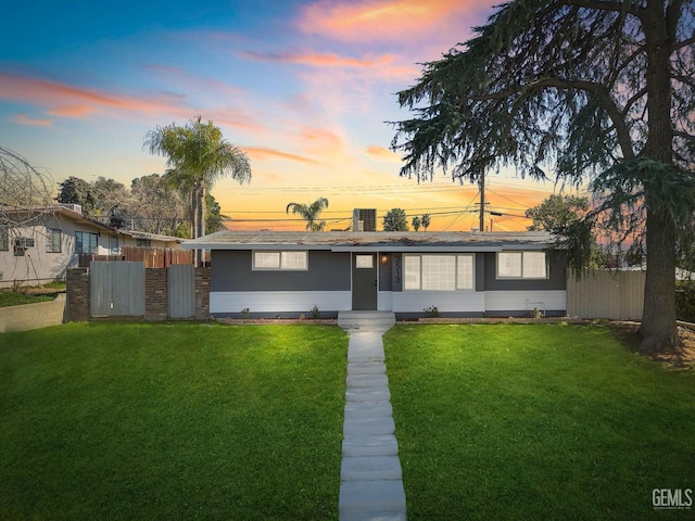 view of front of home with a front lawn and fence