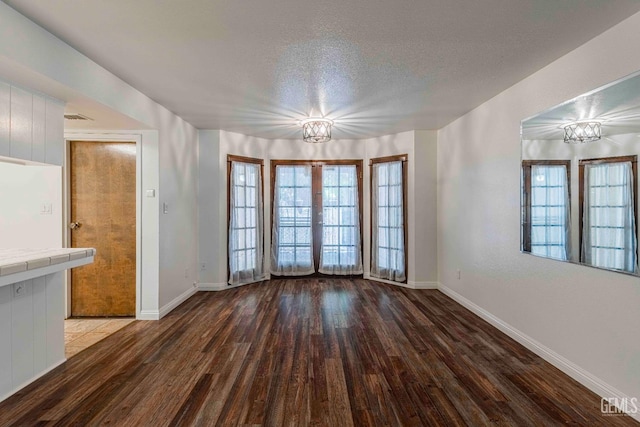 5500 Lennox Ave Unit 20, Bakersfield, CA 93309 - unfurnished dining area featuring a chandelier, wood finished floors, a textured ceiling, and french doors
