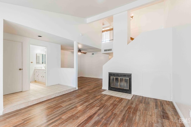 5500 Lennox Ave Unit 20, Bakersfield, CA 93309 - unfurnished living room with wood finished floors, ceiling fan, and a fireplace with flush hearth