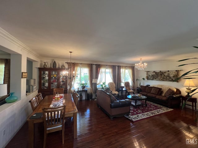 living room featuring dark hardwood / wood-style flooring, ornamental molding, and a notable chandelier