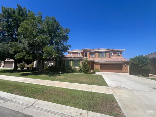 mediterranean / spanish-style house featuring a garage and a front lawn