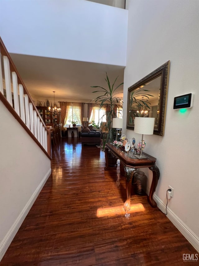 hall featuring a notable chandelier and dark wood-type flooring