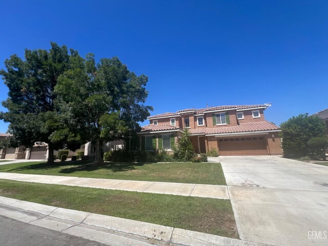 mediterranean / spanish-style house with a garage and a front lawn