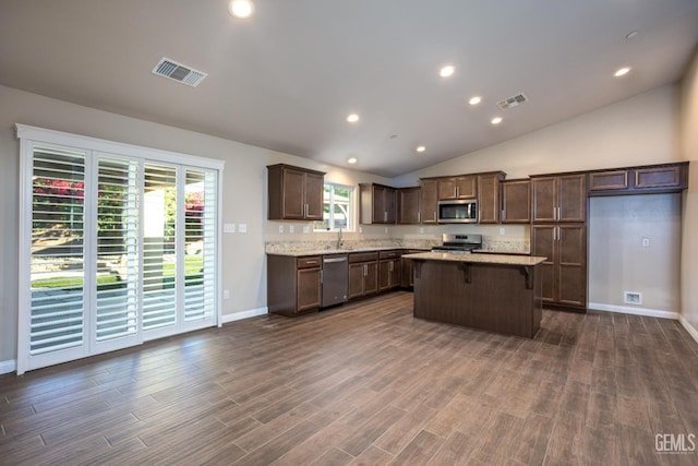 9029 Midnight Creek Way, Bakersfield, CA 93311 - kitchen with stainless steel appliances, a kitchen island, dark brown cabinetry, dark wood-type flooring, and lofted ceiling