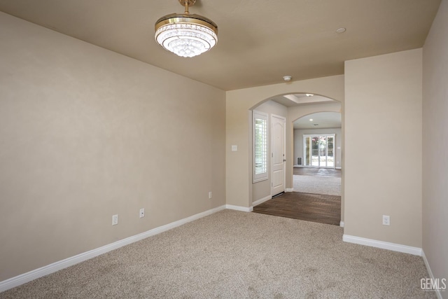 9029 Midnight Creek Way, Bakersfield, CA 93311 - spare room with arched walkways, dark carpet, and a chandelier